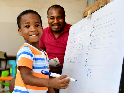 Smiling child next to teacher